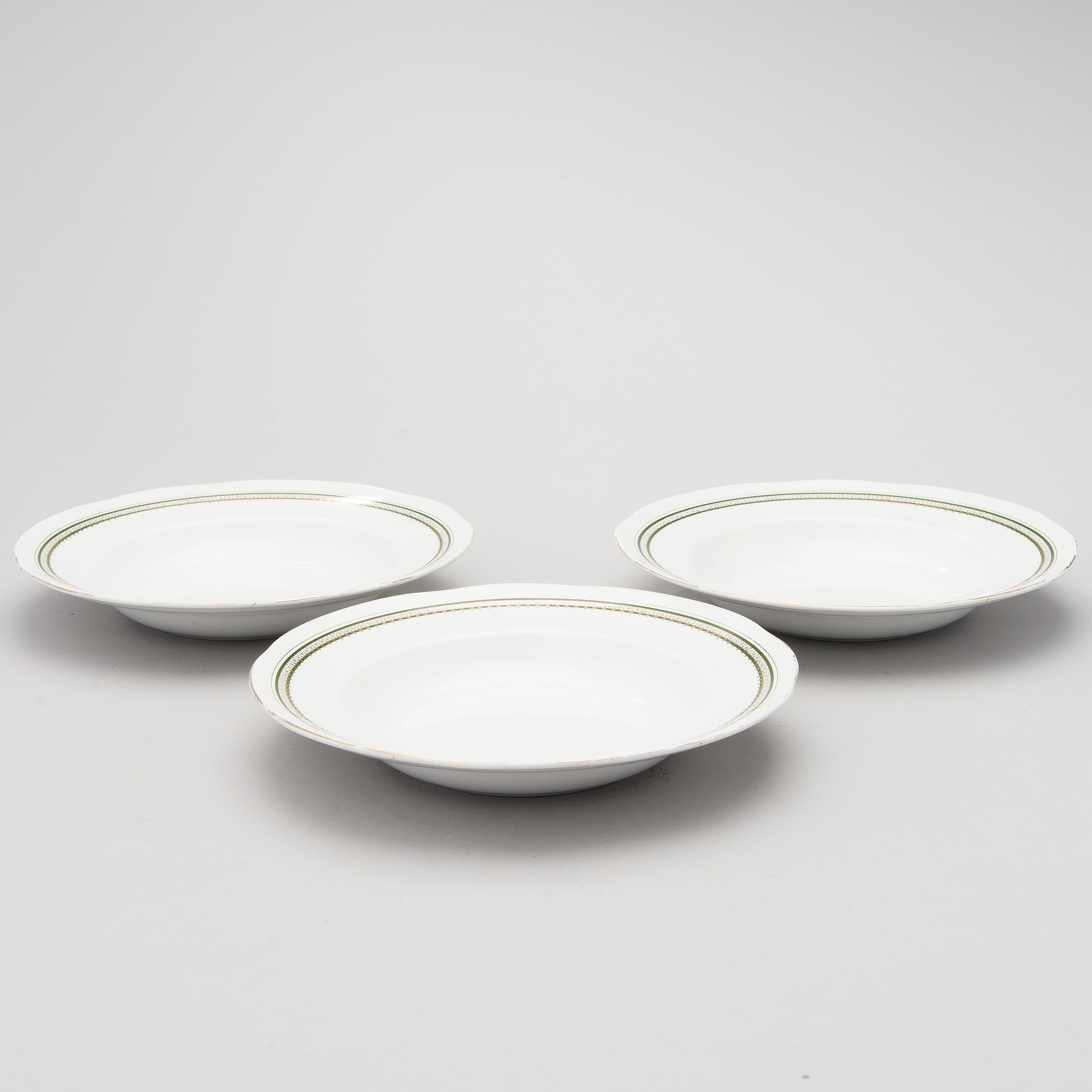 A set of three faience rim soup bowls, early 20th Century. Bukowskis