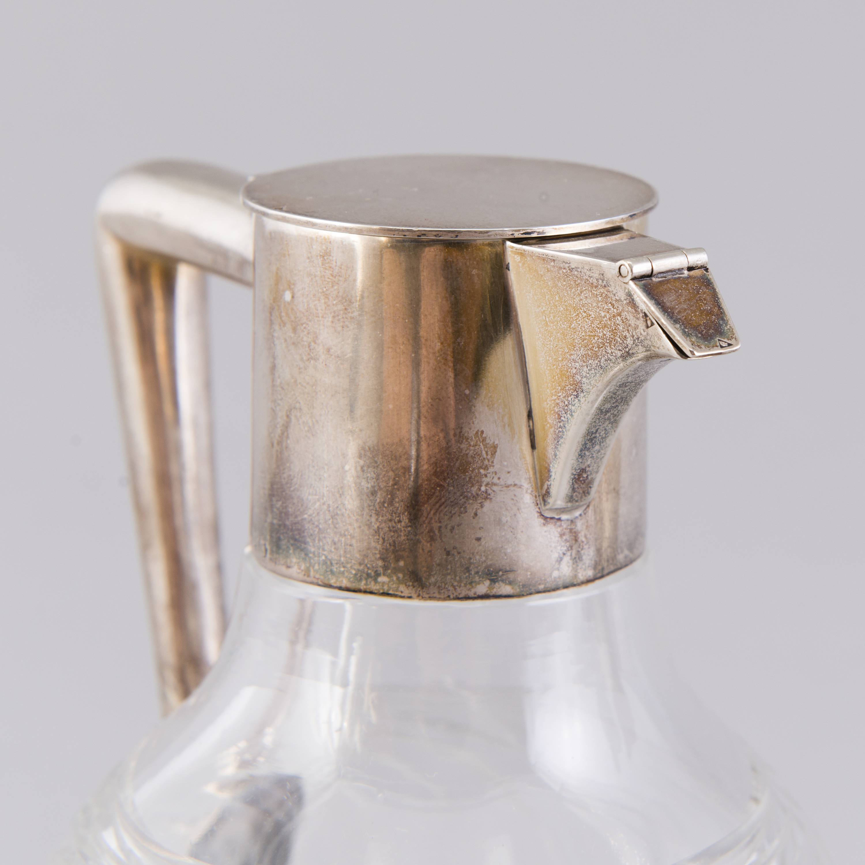 Two glass carafes with hinged silver lids and silver handles, K