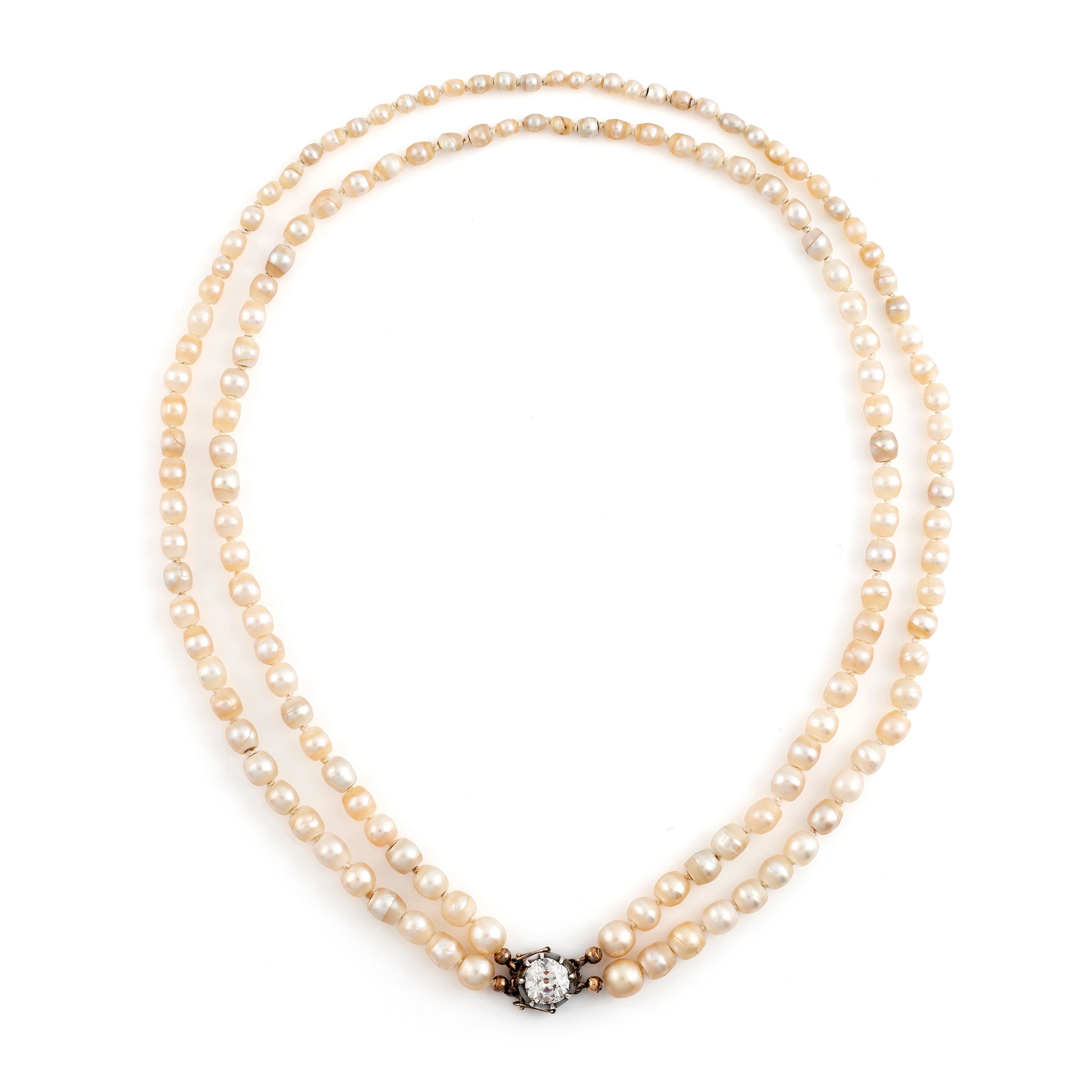 A two strand natural pearl necklace with a silver clasp set with an old
