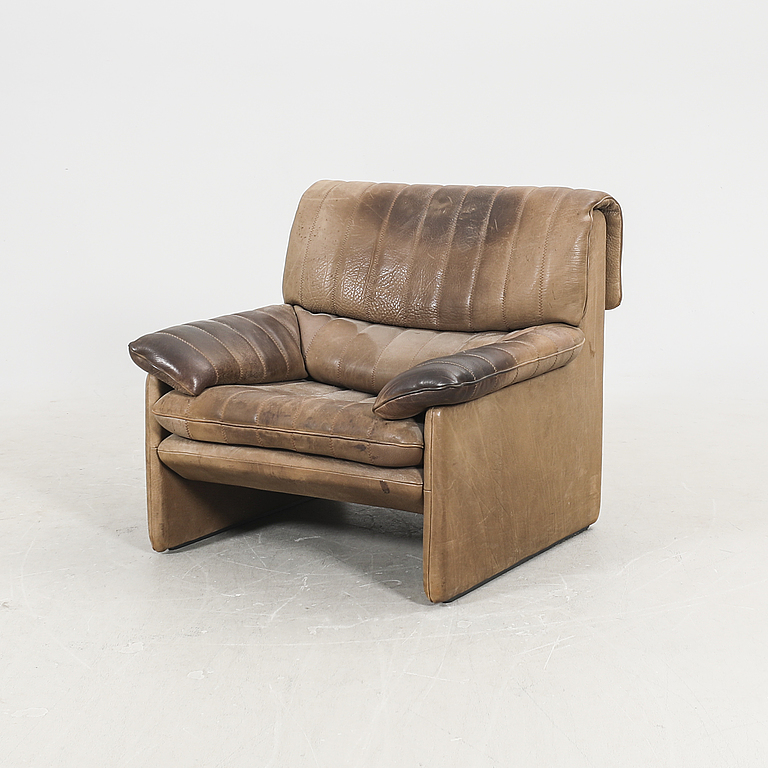 A set of two leather armchairs and a stool by De Sede, Schweiz second half of the 20th century.