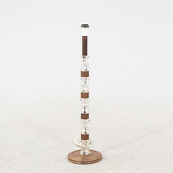 A 1970s wood and glass floor lamp.