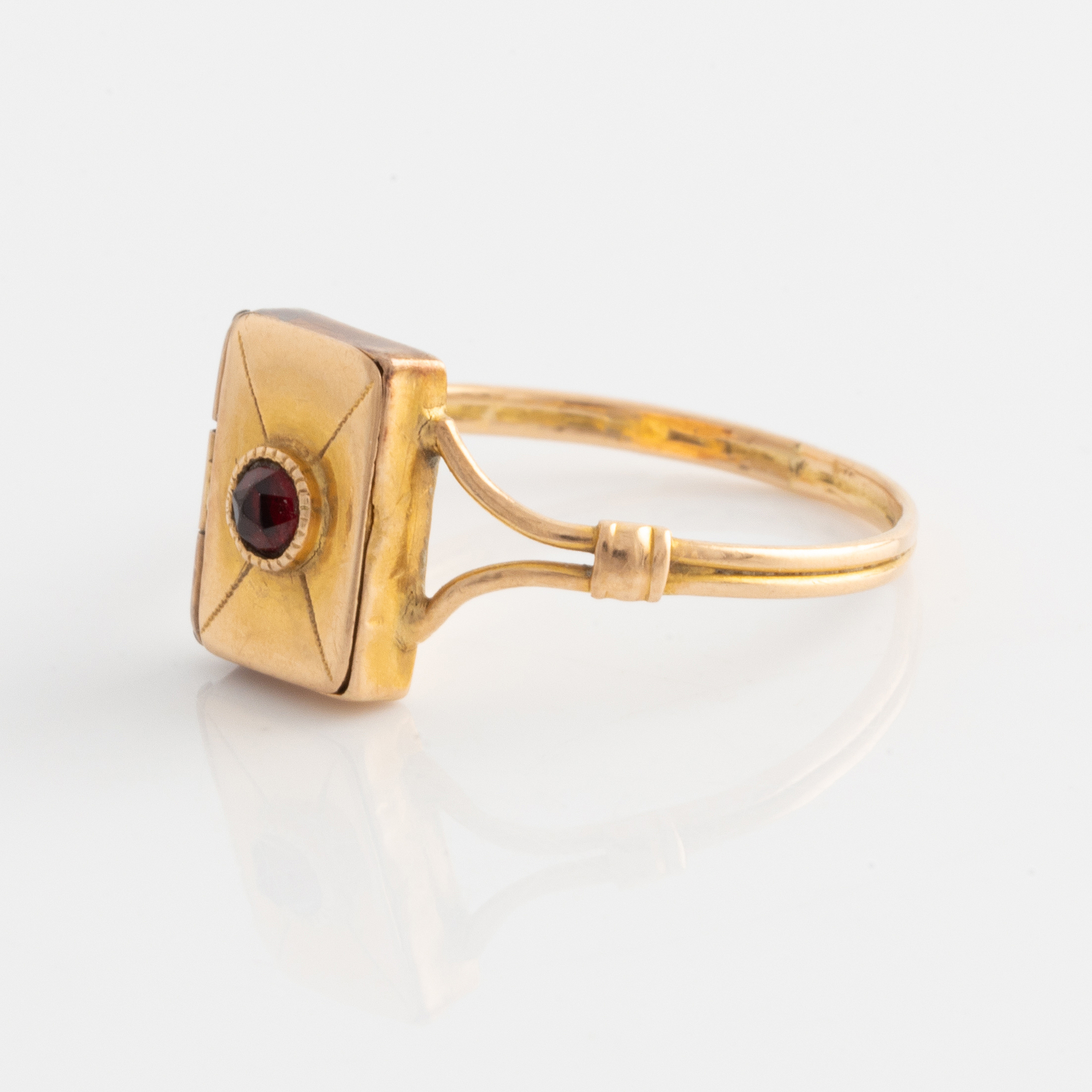 Ring, 18K guld med liten gömma och röd sten. - Bukowskis