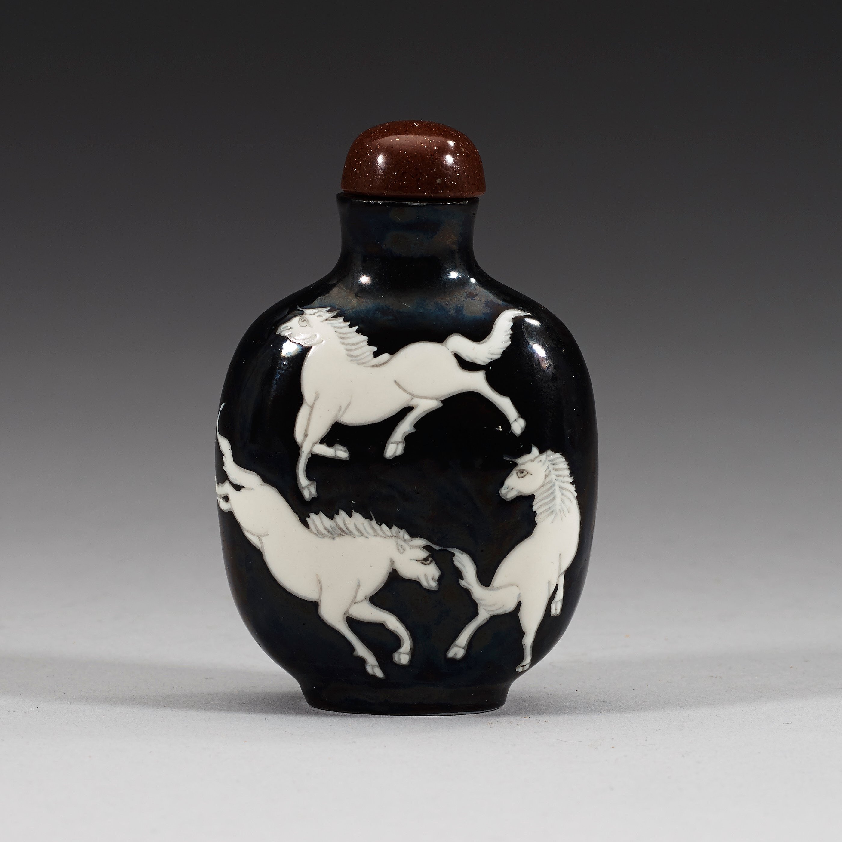 An enamelled porcelain snuff bottle with stopper, Qing dynasty (1644