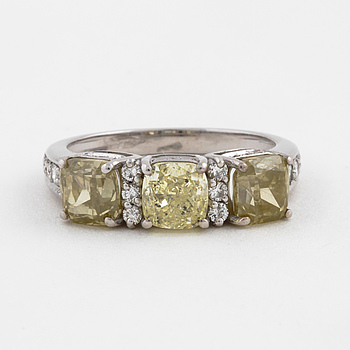 A oval cut yellow diamond and brilliant cut white diamond ring.