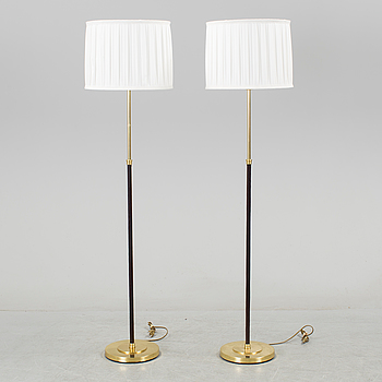 A pair of brass and leather floor lights by Blond Belysning.