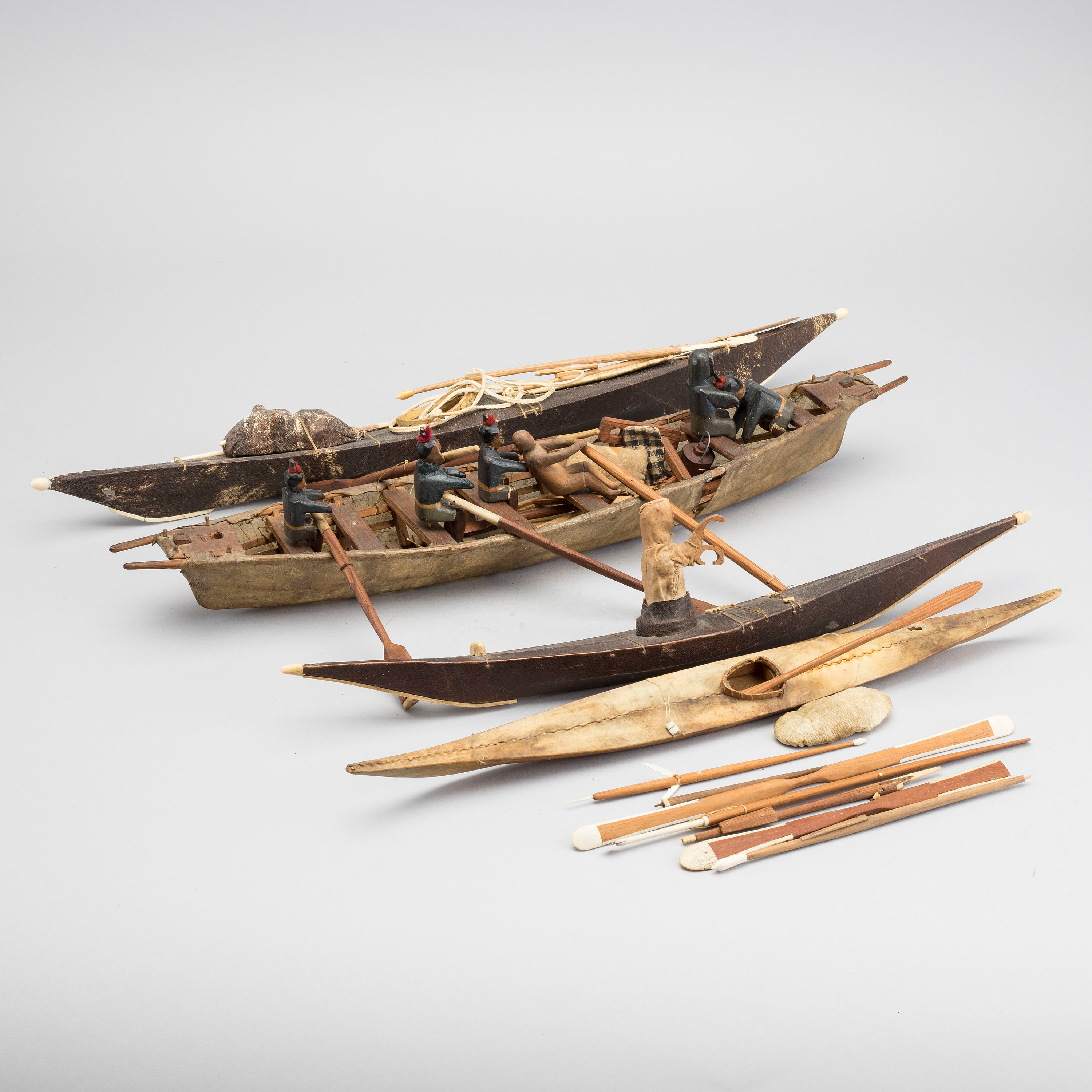 AN UMIAK AND THREE KAJAKS, MODEL BOATS GREENLAND, WITH FIGURES, PADDLES
